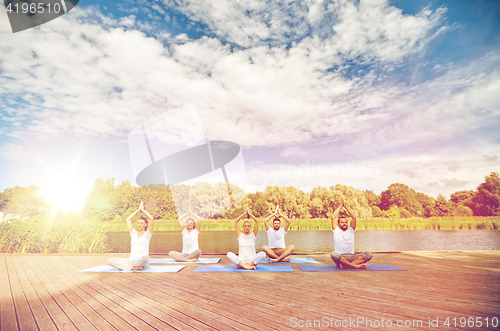 Image of close up of people making yoga exercises outdoors