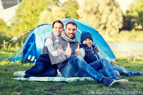 Image of happy family with tent at camp site