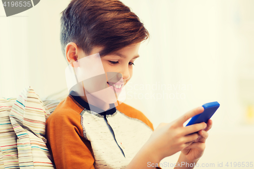 Image of boy with smartphone texting or playing at home