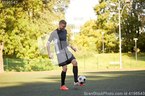 Image of soccer player playing with ball on field