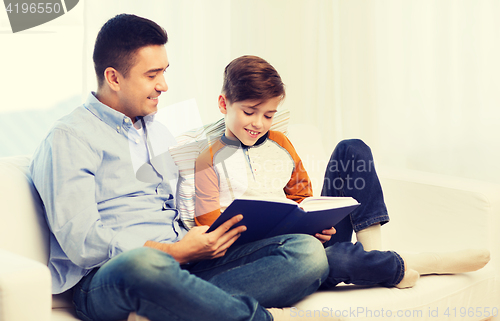 Image of happy father and son reading book at home