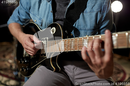 Image of man playing guitar at studio rehearsal