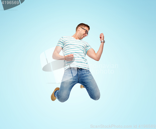 Image of happy man jumping and playing imaginary guitar