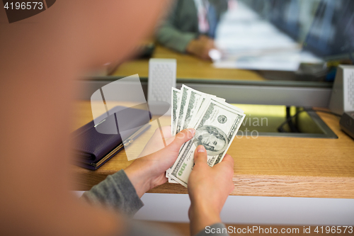 Image of hands with money at bank or currency exchanger