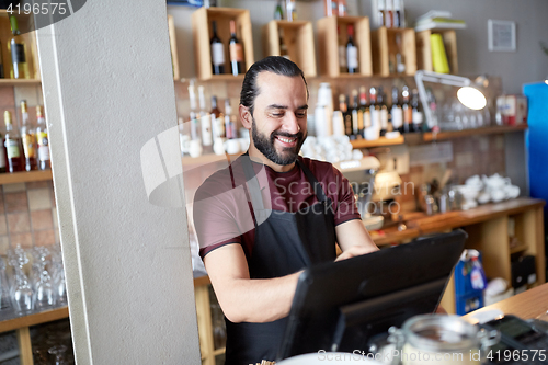 Image of happy man or waiter at bar cashbox