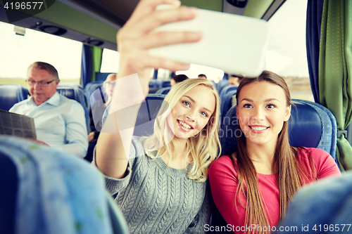 Image of women taking selfie by smartphone in travel bus