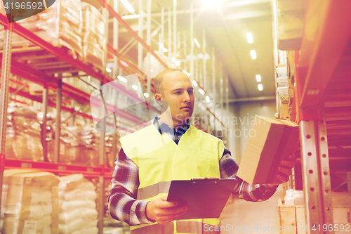 Image of man with clipboard in safety vest at warehouse