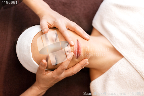 Image of woman having face and head massage at spa