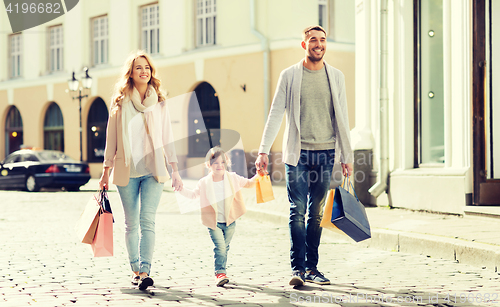 Image of happy family with child and shopping bags in city