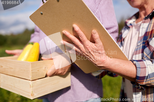 Image of happy senior couple with squashes at farm