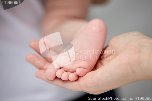 Image of close up of newborn baby foot in mother hand