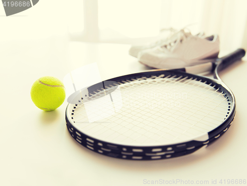 Image of close up of tennis racket with ball and sneakers