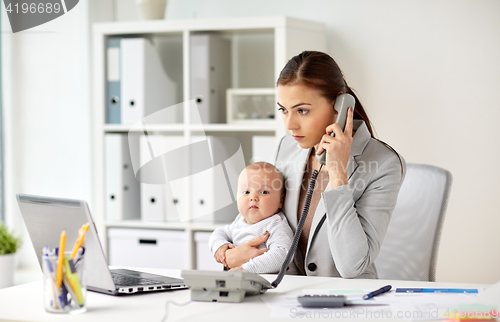 Image of businesswoman with baby calling on phone at office