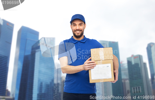 Image of happy delivery man with parcel boxes