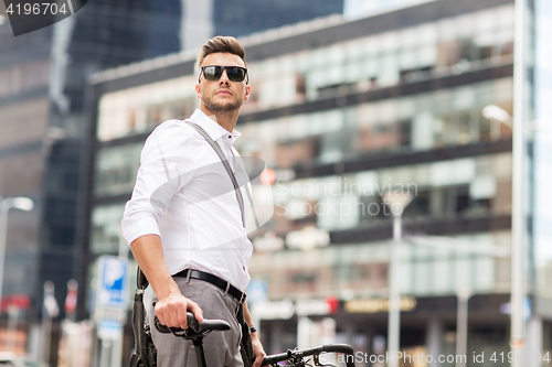 Image of young man with bicycle on city street