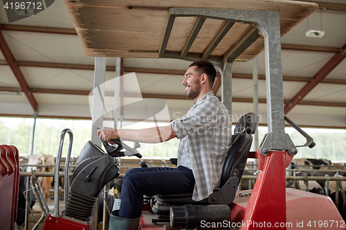 Image of man or farmer driving tractor at farm