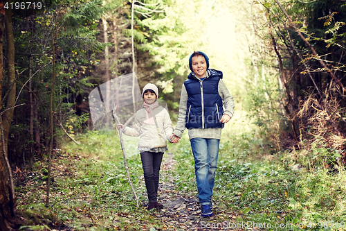 Image of two happy kids walking along forest path