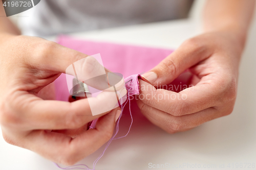 Image of woman with needle stitching fabric pieces