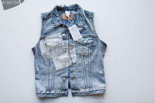 Image of denim vest or waistcoat with price tag on white