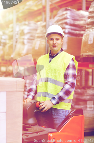 Image of man on forklift loading boxes at warehouse