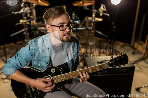 Image of man playing guitar at studio rehearsal