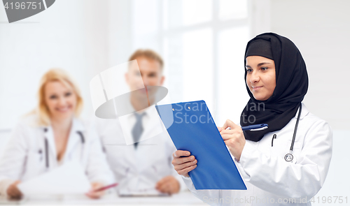 Image of muslim female doctor in hijab with clipboard
