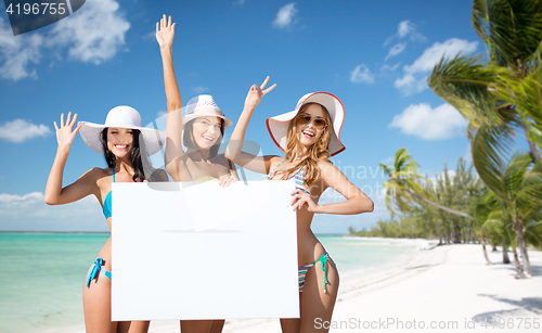 Image of happy young women with white board on summer beach
