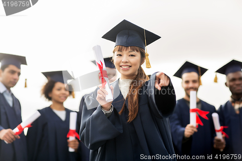 Image of happy student with diploma pointing finger at you