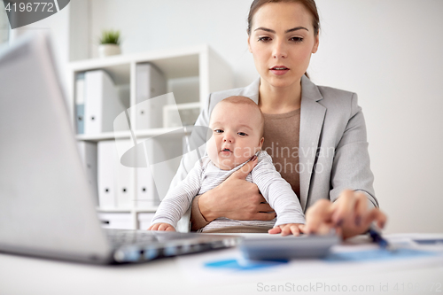 Image of happy businesswoman with baby and laptop at office