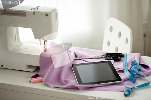 Image of sewing machine, tablet pc, scissors and ruler