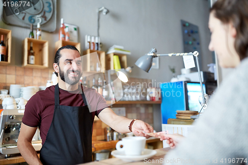 Image of man or waiter serving customer at coffee shop