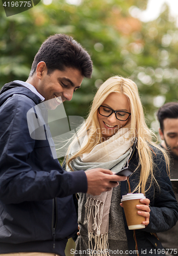 Image of happy friends with smartphone and coffee outdoors