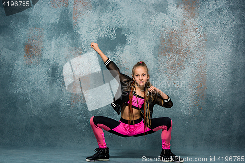 Image of Young girl break dancing on wall background.