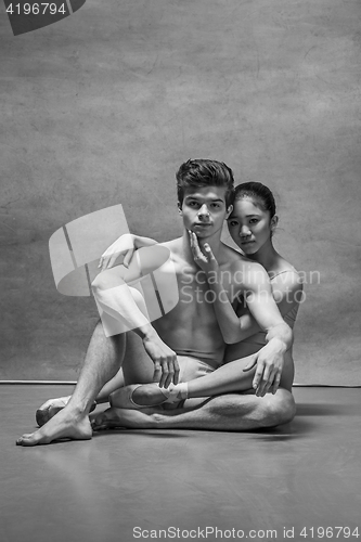 Image of Couple of ballet dancers posing over gray background