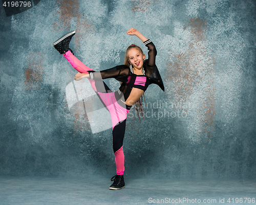 Image of Young girl break dancing on wall background.