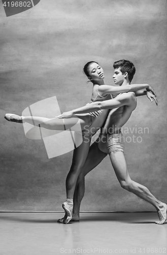 Image of Couple of ballet dancers posing over gray background