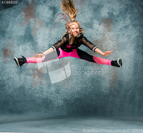 Image of Young girl break dancing on wall background.