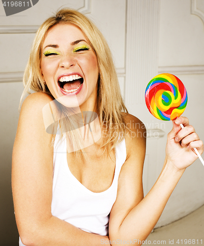 Image of young pretty blonde girl with colorful candy happy smiling, emotional posing, lifestyle people concept