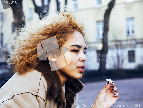 Image of young pretty girl teenage outside smoking cigarette close up, looking like real junky, social issues concept