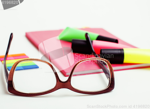 Image of business, education and technology concept - close up of notebook, paper stickers, glasses, pencil different new stuff on white background