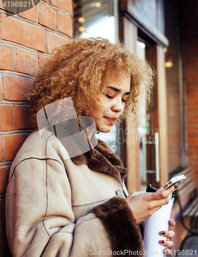 Image of young pretty african american women drinking coffee outside in cafe, modern real business woman lifestyle concept