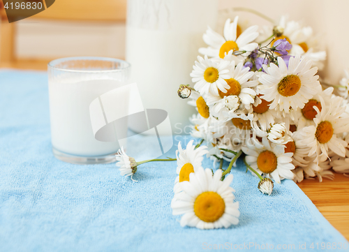 Image of Simply stylish wooden kitchen with bottle of milk and glass on table, summer flowers camomile, healthy foog moring concept noone 