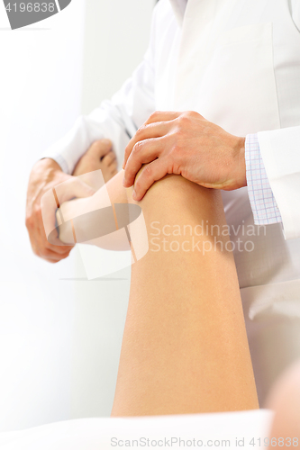 Image of A physiotherapist massaged patient&#39;s leg.