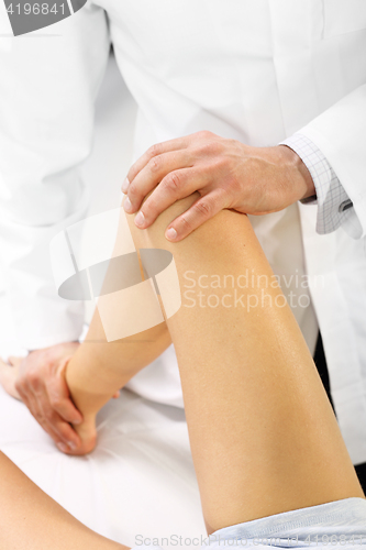 Image of Massage and rehabilitation. A physiotherapist massaged patient&#39;s leg.