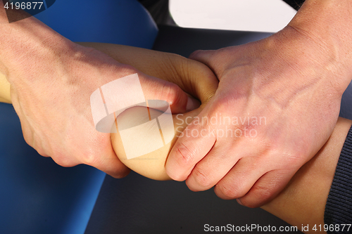 Image of Massage and rehabilitation. A physiotherapist massaged patient&#39;s leg.