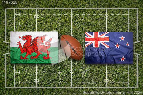 Image of Wales vs. New Zealand flags on rugby field