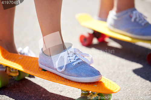 Image of close up of feet riding skateboards on city street