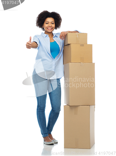 Image of happy african woman with boxes showing thumbs up