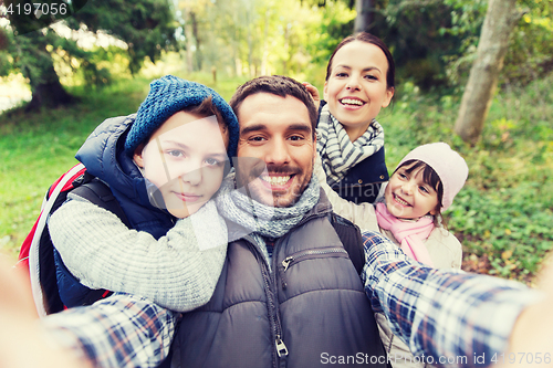 Image of family with backpacks taking selfie and hiking