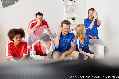 Image of friends or football fans watching soccer at home